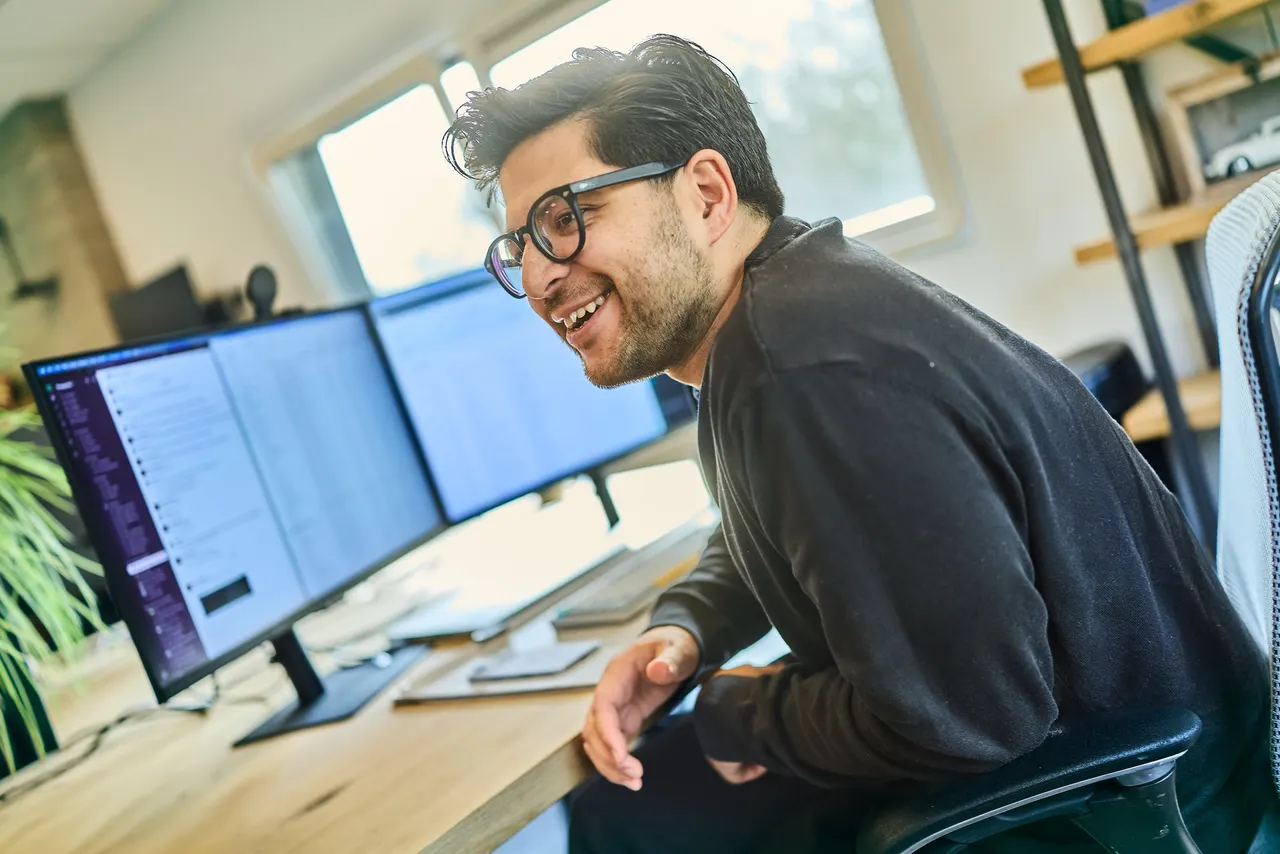 A colleague laughing at his desk